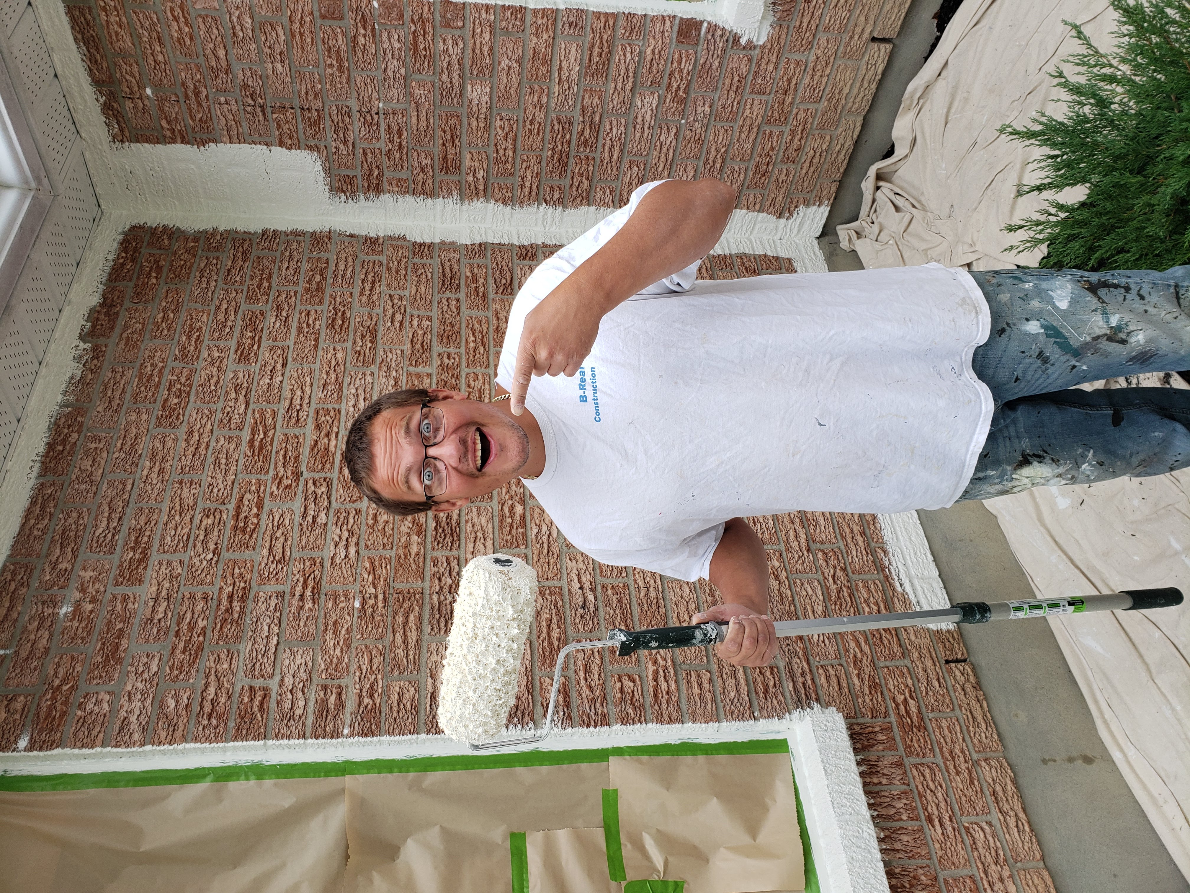 Painter applying exterior coating on site